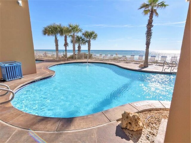 view of pool featuring a water view, central air condition unit, and a patio area