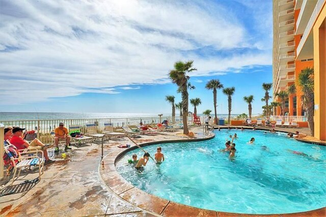 view of swimming pool featuring a patio and a water view