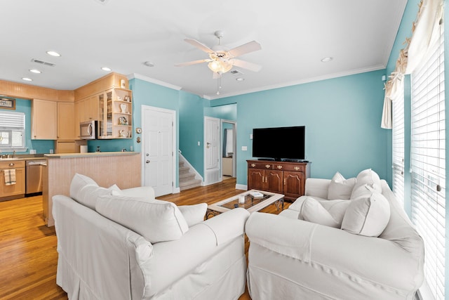 living room featuring light wood-type flooring, crown molding, and ceiling fan