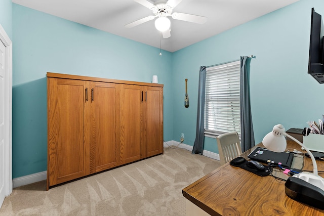 carpeted home office featuring ceiling fan