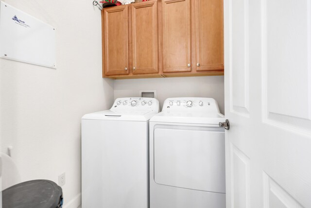 washroom with cabinets and washer and dryer