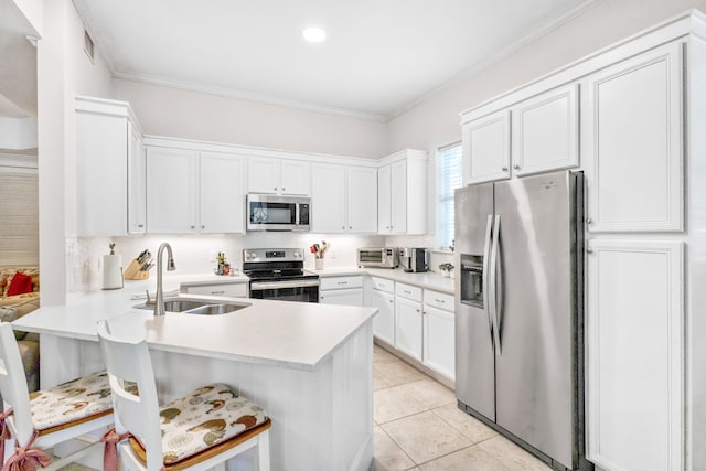 kitchen with white cabinets, kitchen peninsula, appliances with stainless steel finishes, and sink