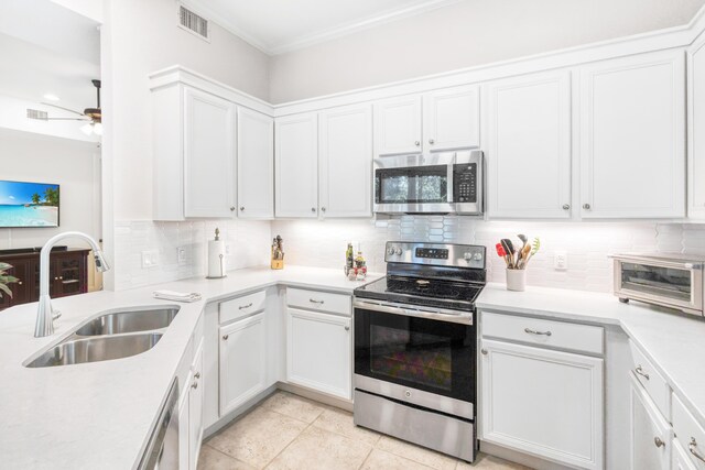 kitchen with tasteful backsplash, white cabinetry, appliances with stainless steel finishes, and sink