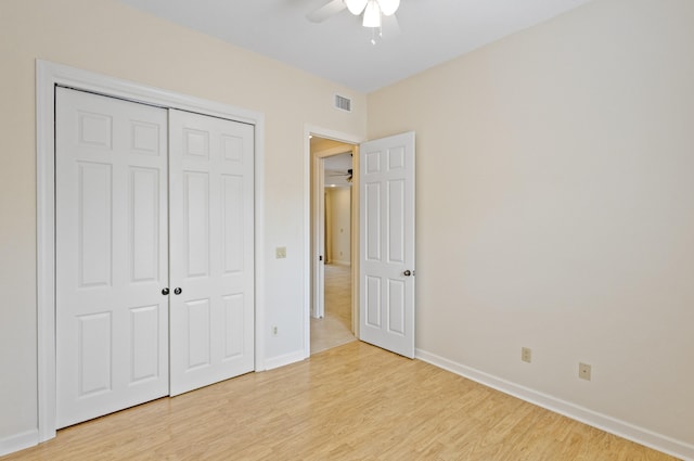 unfurnished bedroom featuring a closet, light wood-type flooring, and ceiling fan