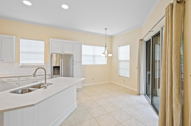 kitchen featuring white cabinetry, pendant lighting, sink, and stainless steel fridge