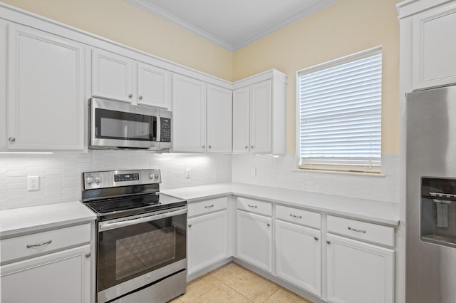 kitchen featuring ornamental molding, stainless steel appliances, white cabinetry, light tile patterned floors, and decorative backsplash