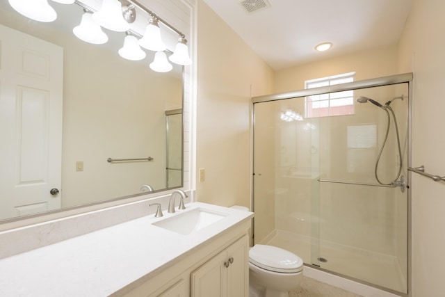 bathroom featuring vanity, toilet, and a shower with shower door