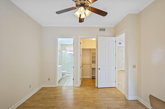 2252 Crystal Cove Ln Unit 2252, Miramar Beach, FL 32550 - unfurnished bedroom featuring a walk in closet, ornamental molding, light wood finished floors, a closet, and baseboards