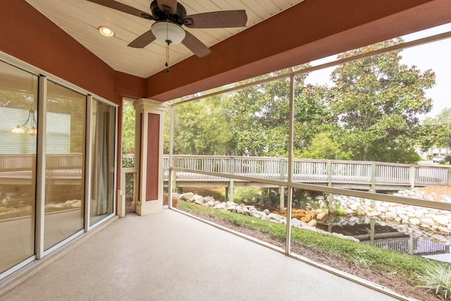 unfurnished sunroom featuring ceiling fan, wood ceiling, and decorative columns