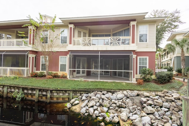 back of property featuring a balcony and a sunroom