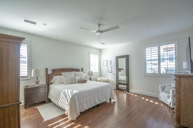 bedroom with multiple windows, hardwood / wood-style flooring, and ceiling fan