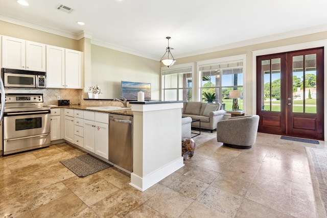 kitchen with sink, white cabinetry, kitchen peninsula, hanging light fixtures, and appliances with stainless steel finishes