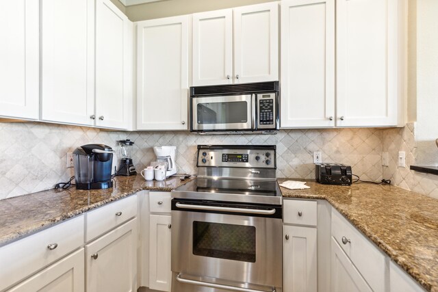 kitchen featuring stainless steel appliances, white cabinets, stone counters, and tasteful backsplash