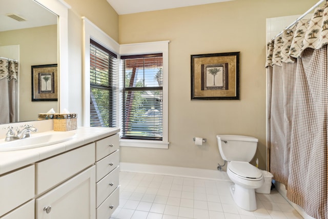 bathroom featuring tile patterned flooring, walk in shower, vanity, and toilet