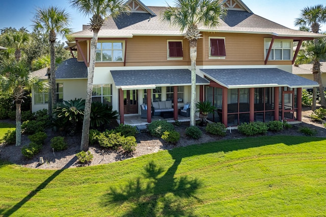 rear view of property with a sunroom, a lawn, and a patio