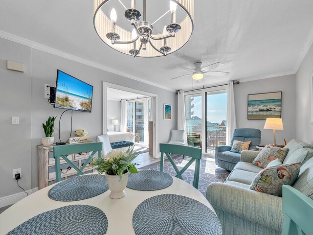 living room with ceiling fan with notable chandelier and crown molding