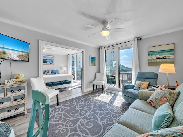 living room with wood-type flooring, ceiling fan, and crown molding