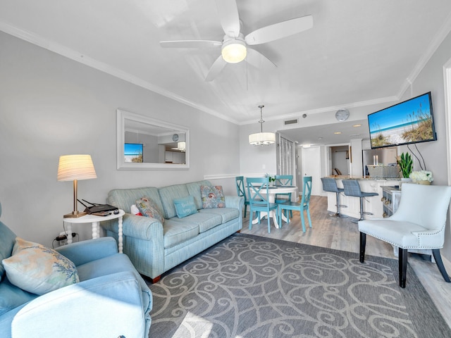 living room featuring ornamental molding, dark wood-type flooring, and ceiling fan