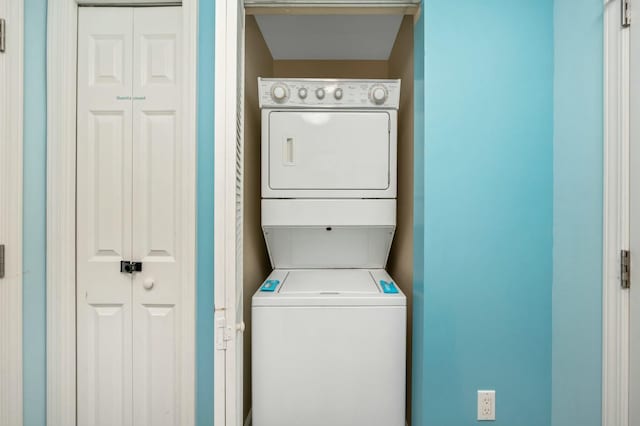 washroom featuring stacked washer and clothes dryer