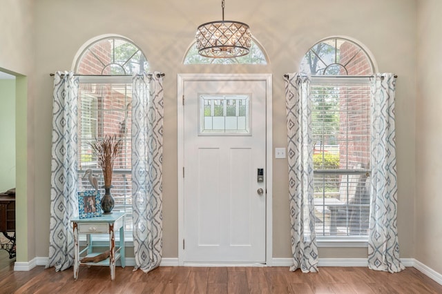 entrance foyer with plenty of natural light, hardwood / wood-style floors, and a notable chandelier