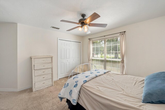 carpeted bedroom featuring ceiling fan and a closet