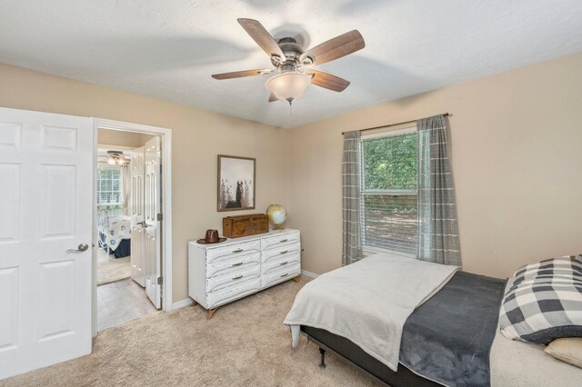 bedroom featuring ceiling fan and light carpet