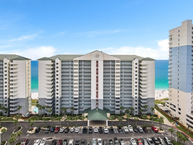 view of building exterior with a water view and a beach view