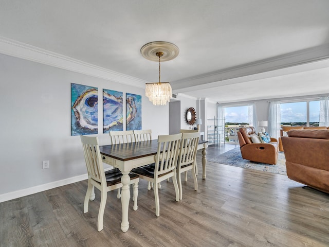 dining space with wood-type flooring, a notable chandelier, and crown molding