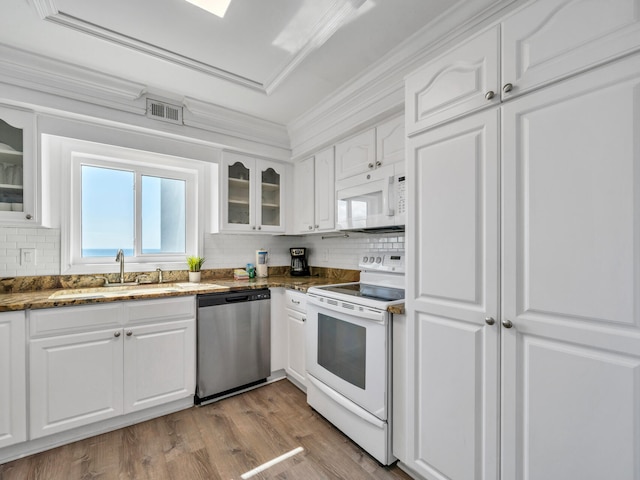 kitchen with white appliances, white cabinetry, sink, and light hardwood / wood-style flooring