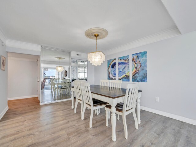 dining room with ornamental molding, a chandelier, and hardwood / wood-style floors