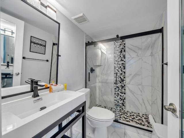 bathroom featuring vanity, a shower with shower door, and toilet