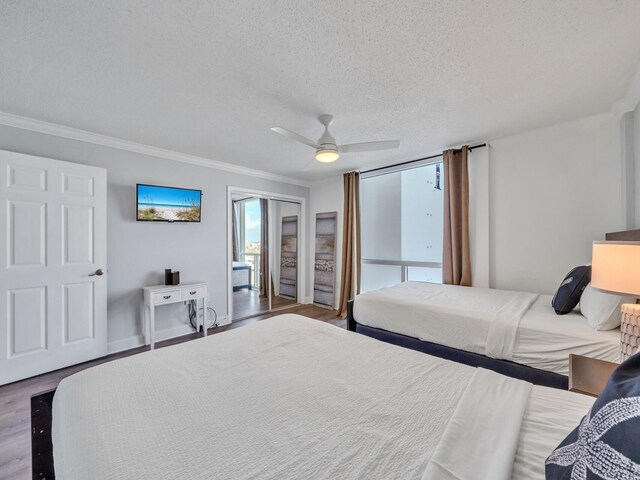 bedroom with ornamental molding, ceiling fan, hardwood / wood-style flooring, and a textured ceiling