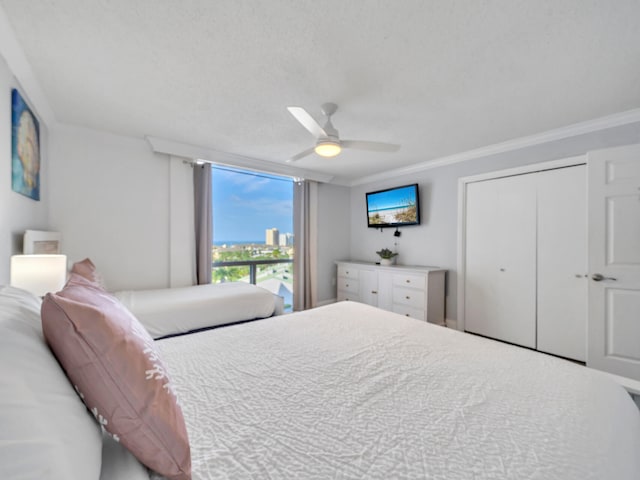 bedroom featuring ceiling fan, a textured ceiling, a closet, and crown molding