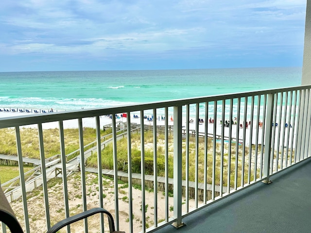 balcony with a water view and a view of the beach