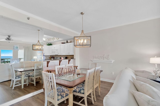 dining space with ceiling fan, dark hardwood / wood-style floors, and crown molding