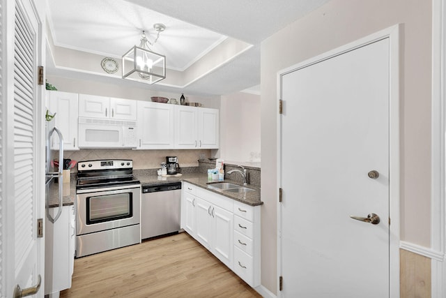 kitchen with light wood-type flooring, a chandelier, sink, white cabinetry, and appliances with stainless steel finishes