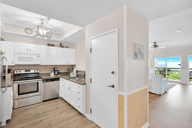 kitchen featuring sink, ceiling fan with notable chandelier, white cabinetry, light hardwood / wood-style flooring, and appliances with stainless steel finishes