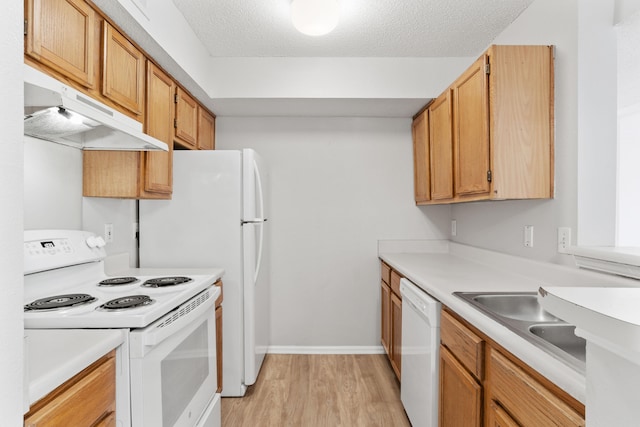 kitchen with light hardwood / wood-style flooring, white appliances, and a textured ceiling