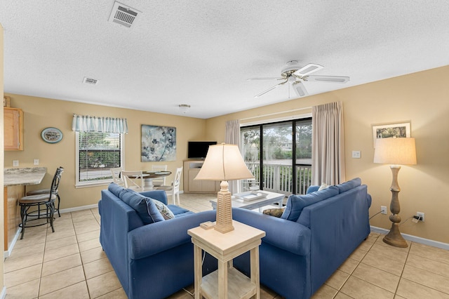 living room with light tile patterned floors, ceiling fan, and a healthy amount of sunlight