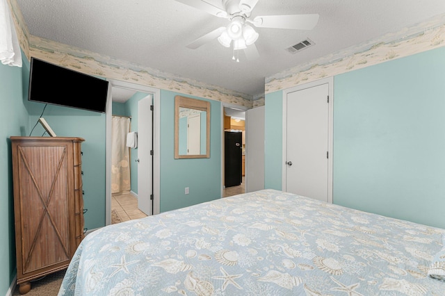 bedroom with a textured ceiling, ceiling fan, and ensuite bathroom