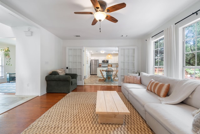 living room with wood-type flooring and ceiling fan