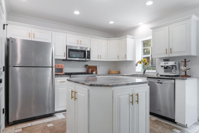 kitchen with a center island, sink, white cabinetry, appliances with stainless steel finishes, and ornamental molding