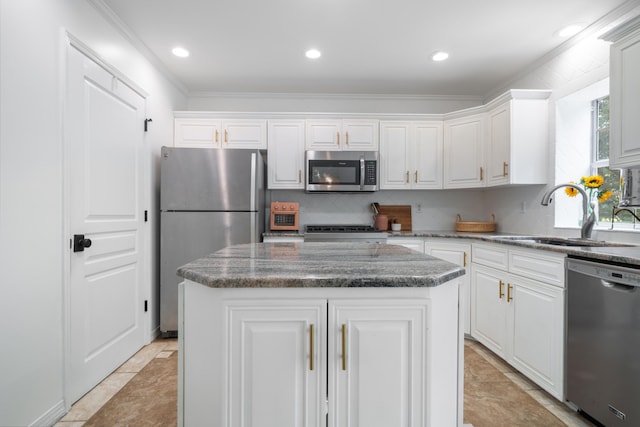 kitchen featuring ornamental molding, appliances with stainless steel finishes, sink, and a center island