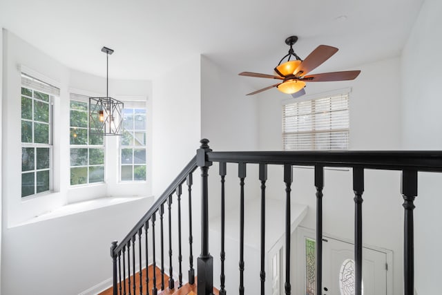 staircase featuring ceiling fan with notable chandelier