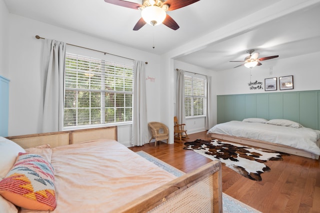 bedroom with ceiling fan, hardwood / wood-style flooring, and multiple windows