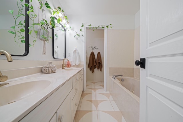 bathroom with a bathtub, vanity, and tile patterned floors