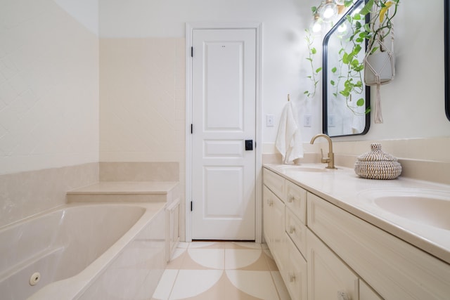 bathroom with a tub to relax in, vanity, and tile patterned floors