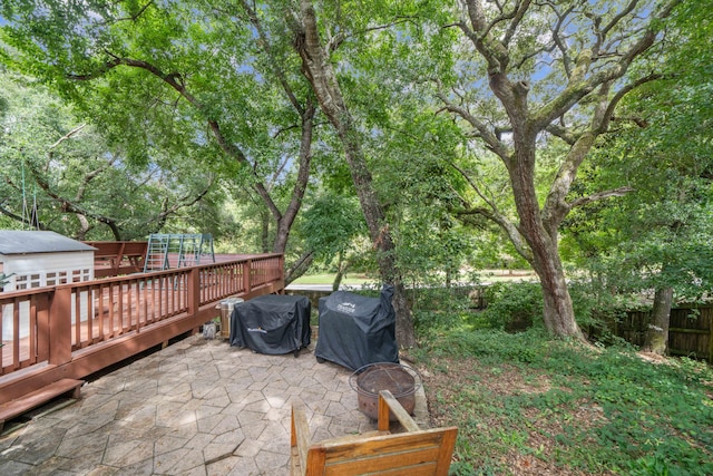 view of yard featuring a patio, a shed, and a deck