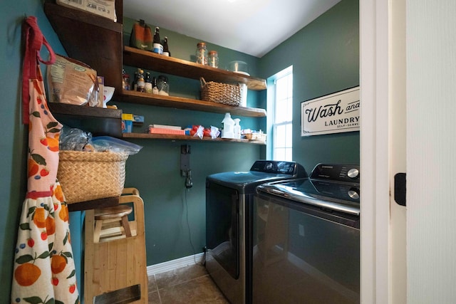 laundry room featuring dark tile patterned flooring and washer and dryer