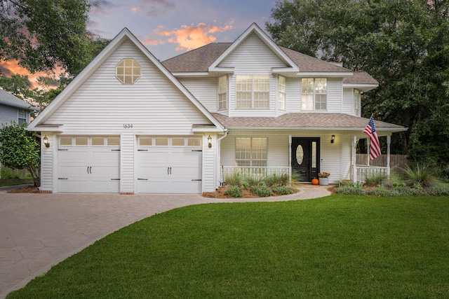 view of front facade featuring a yard, a porch, and a garage